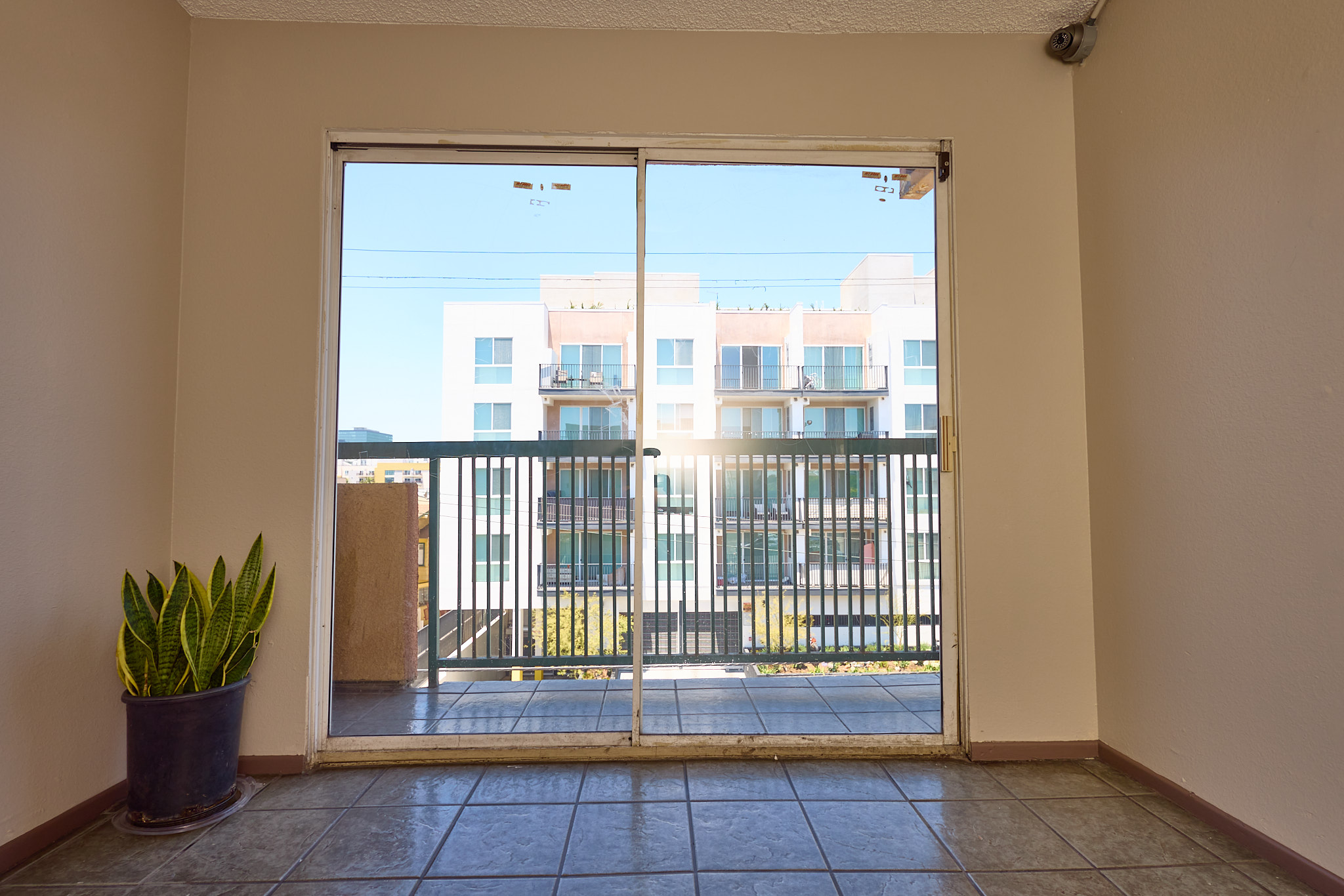 A room with a view of a balcony and buildings outside.